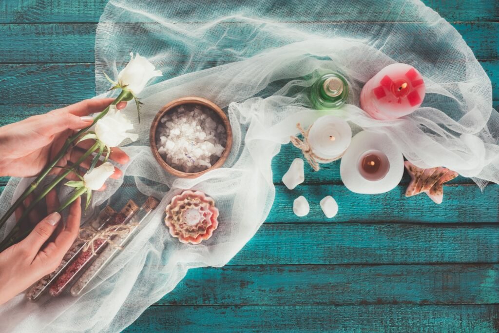 Vista superior de una mujer preparando elementos decorativos para un tratamiento de spa.